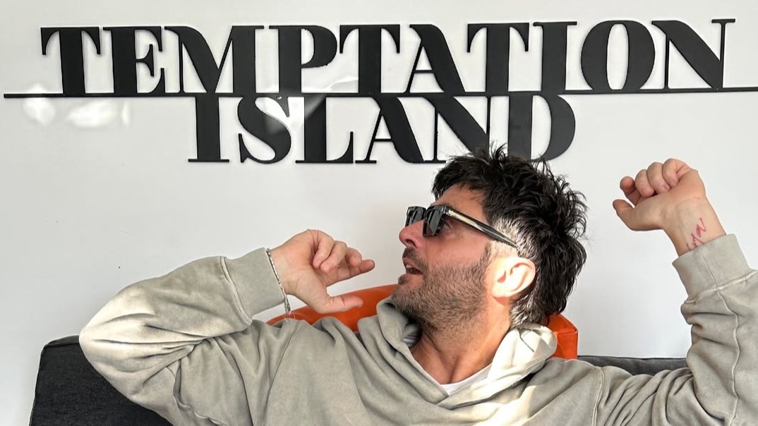 Filippo Bisciglia davanti al logo di Temptation Island 2026