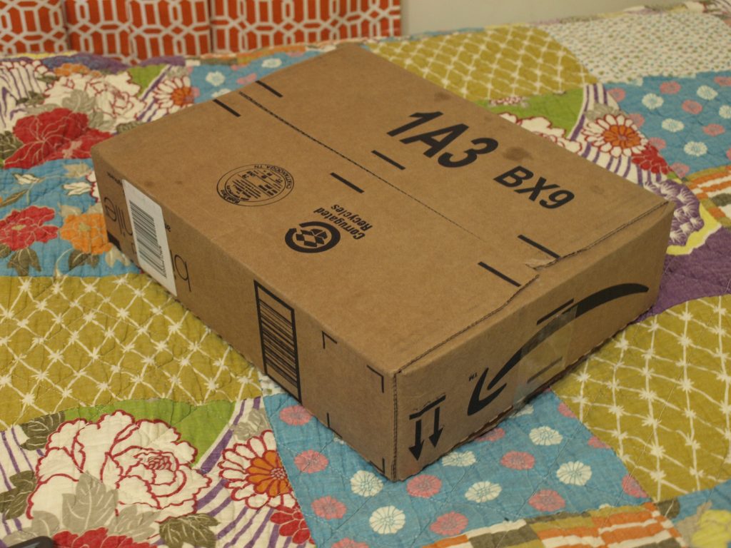 Pacco Amazon su pavimento fotografato da Matthew Paul Argall