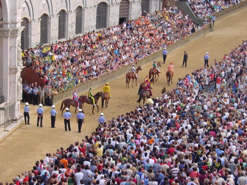 Piazza del Campo durante il Palio di Siena con pubblico e cavalli