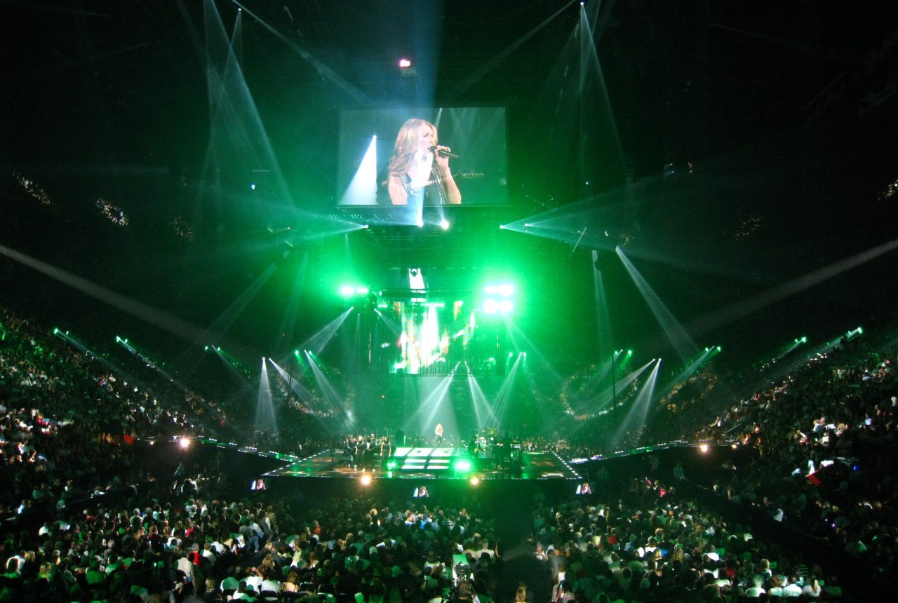 Céline Dion sul palco durante un concerto con luci laser