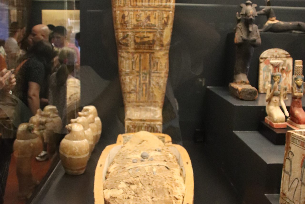 Mummia egizia e coperchio di sarcofago in museo