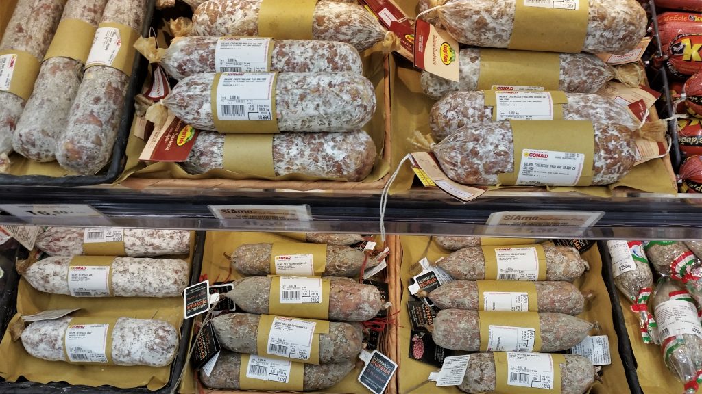 Salami italiani appesi in un banco gastronomico